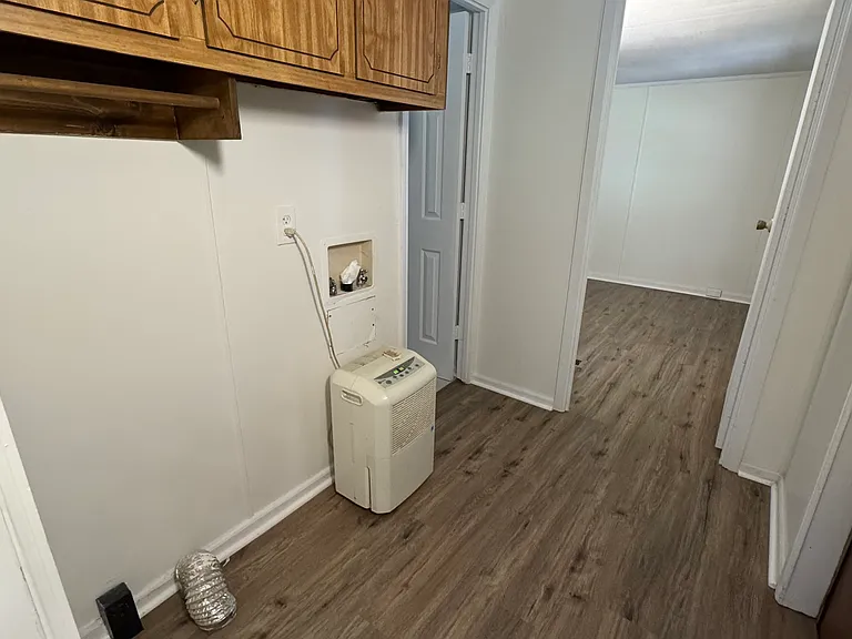 Area for washer and dryer with cabinet storage up above. Back door to the right.
