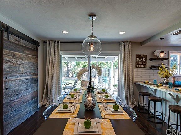 Lots of room for holiday dinners in this stylish dining room with breakfast bar and charming re-claimed wood sliding barn door.