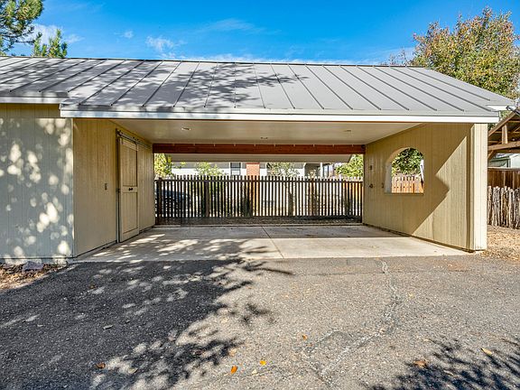 Carport with room for 2.5 cars, and a workshop built out for maximum storage.