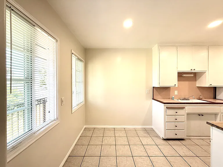 Dining space adjoining the kitchen, looking in from the front entry and living room, with lots of natural light coming in from the east facing windows.
