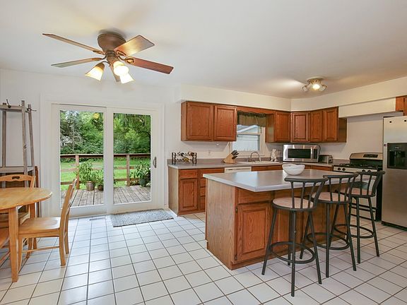 Open kitchen with island and stainless steel appliances and eating area.
