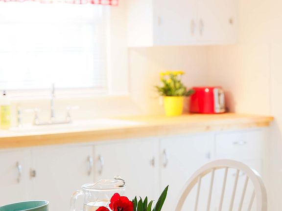 Butcherblock counter, porcelain sink, toaster, dishes, silverware, etc.