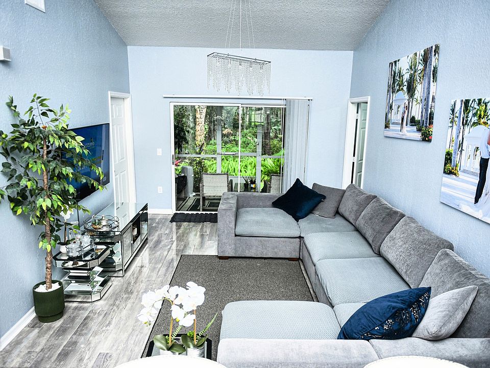 Living Room _ Inviting living room with high ceilings, sleek floors, and access to nature-view lanai