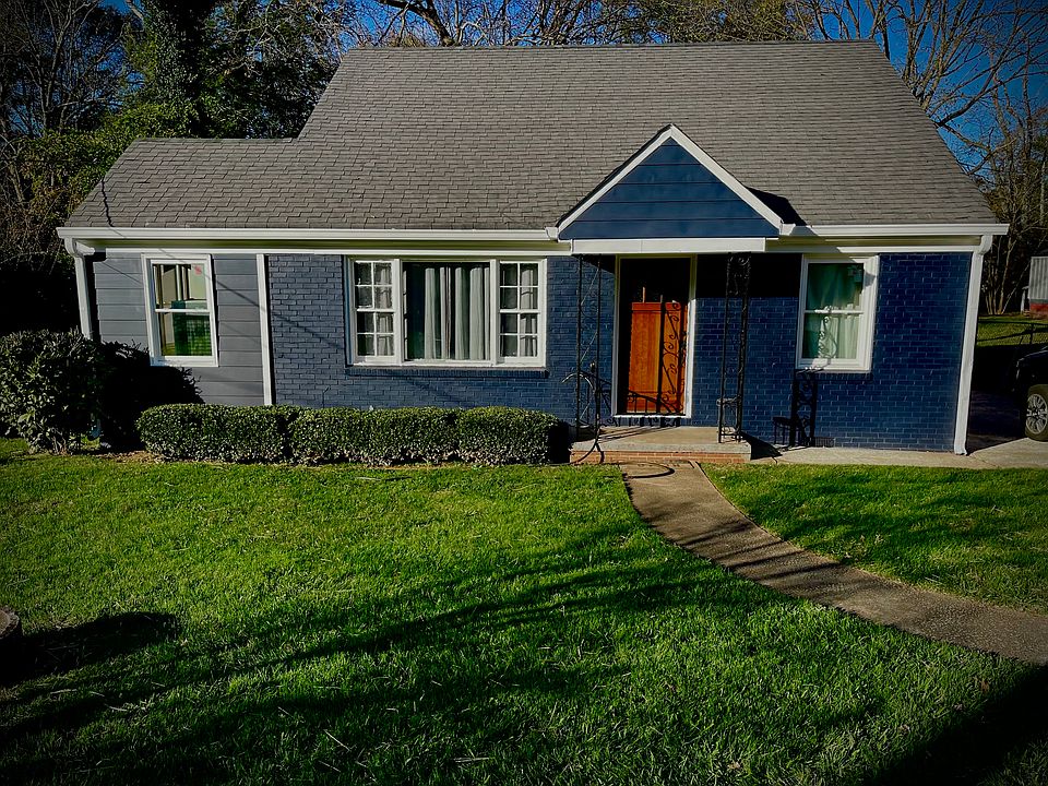 Cozy navy blue cottage with crisp white trim and a warm wood front door. Covered porch, large windows, and neat landscaping create great curb appeal. Located on a quiet, EAV street, this home blends charm, style, and comfort.