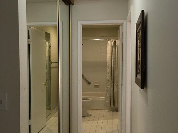Hall with storage leading to bathroom and main BR