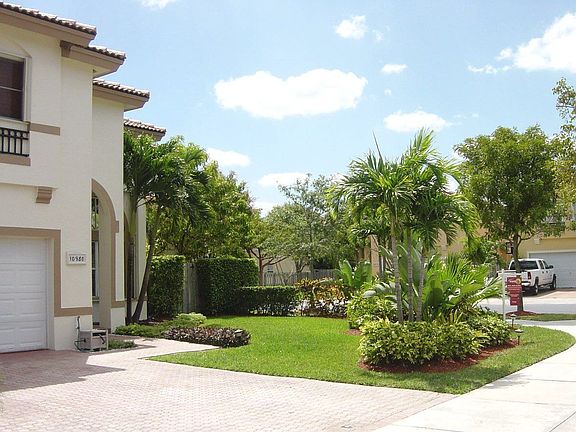 paver driveway , landscaped island and gate entry to back yard