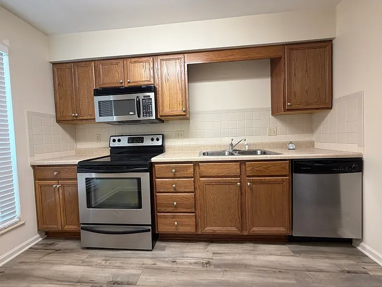 Sunny kitchen with stainless appliances, laundry closet.
