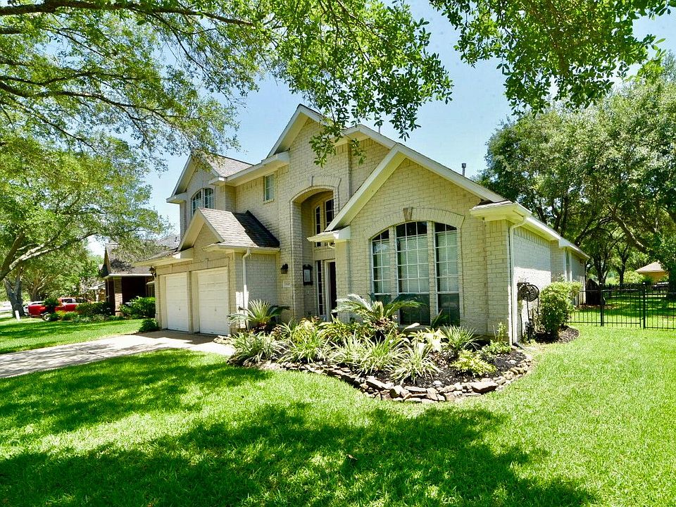 Shaded front view w/ beautiful landscaping.