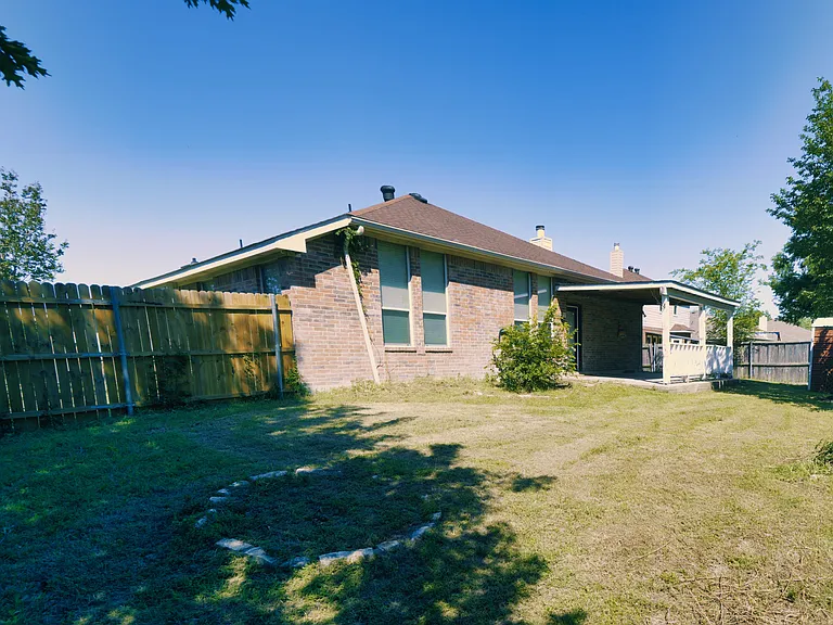 This generous backyard includes a covered porch for shaded relaxation and plenty of space for weekend entertaining