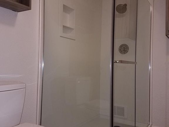 Walk-in shower with solid surface walls and niche
