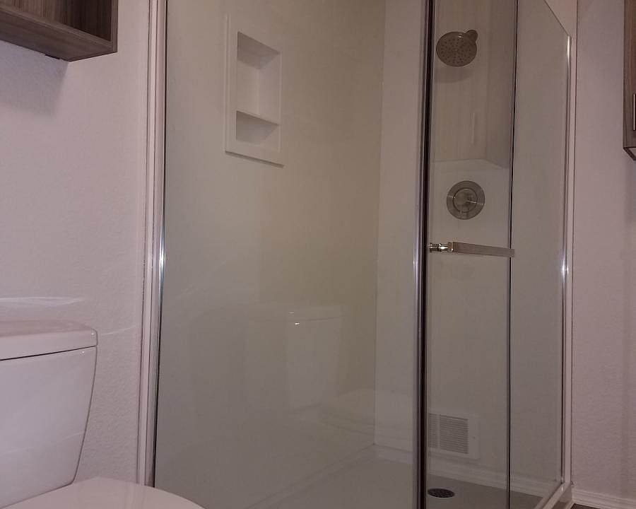 Walk-in shower with solid surface walls and niche