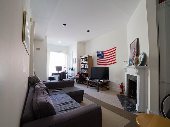 Living room with bay window with view of front yard and historic Victorian houses along T Street