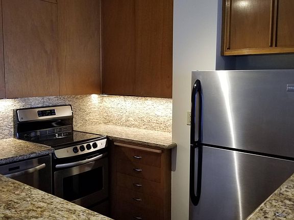 Efficient kitchen with granite and stainless steel appliances, including a dishwasher.