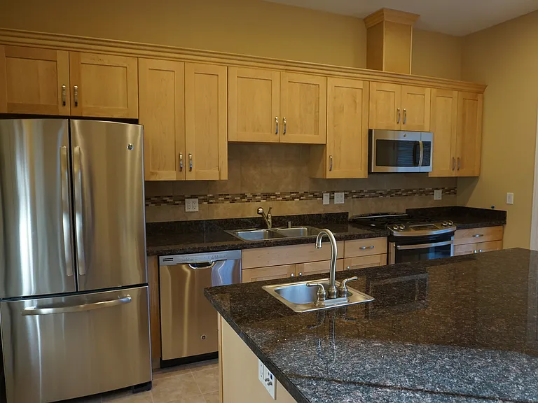 huge kitchen with island , and granite counter tops wet bar and extra large pantry .