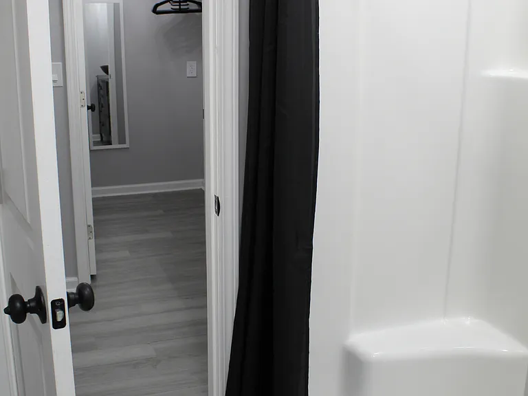 The walk-in shower has double sided built-in seats and shelving nooks.