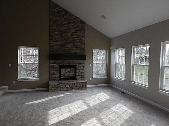 Beautiful family room with stone fireplace and tons of natural light , off of the kitchen