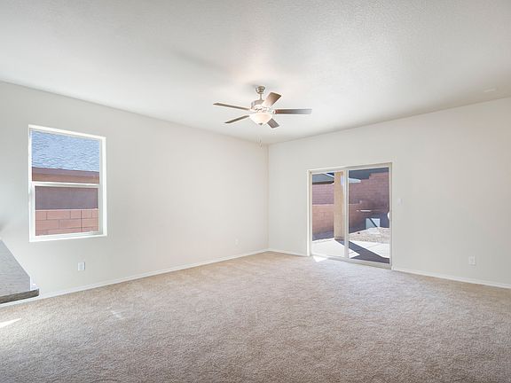 Spacious family room with a ceiling fan and sliding doors.