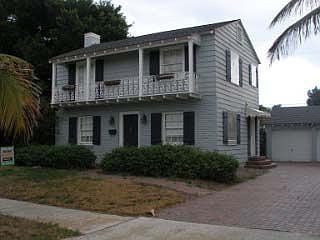 Northwest corner shows covered side entry and large driveway with pavers.