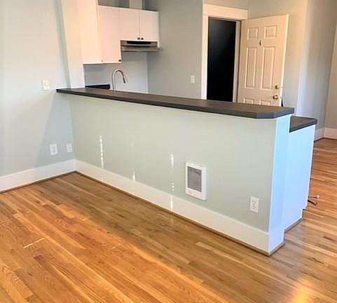 Open kitchen and living room with hardwood floors