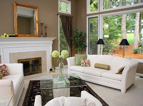 Bright living room with marble fireplace and crown molding.