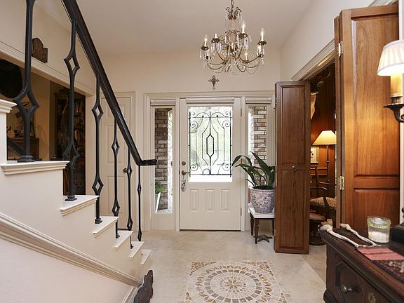 Lovely entry, updated floors with medallion, paneled study with bi-fold doors to the right, large, family room with cathedral ceiling on the left. Updated iron staircase