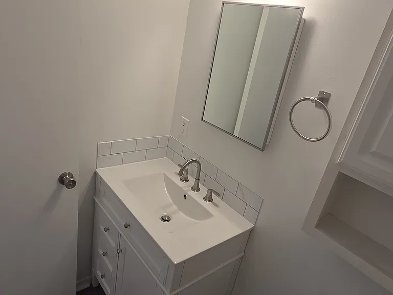 Updated vanity, fixtures, lighting, and decorative backsplash detail.