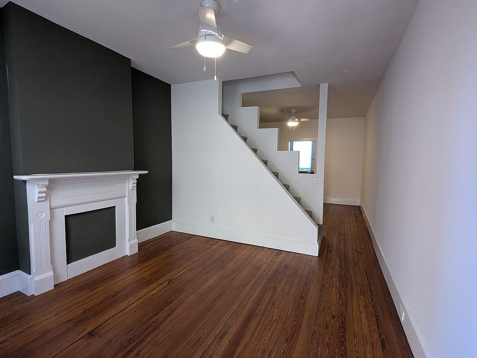Original hardwood floors in both living and dining room, ceiling fans, and open stair.