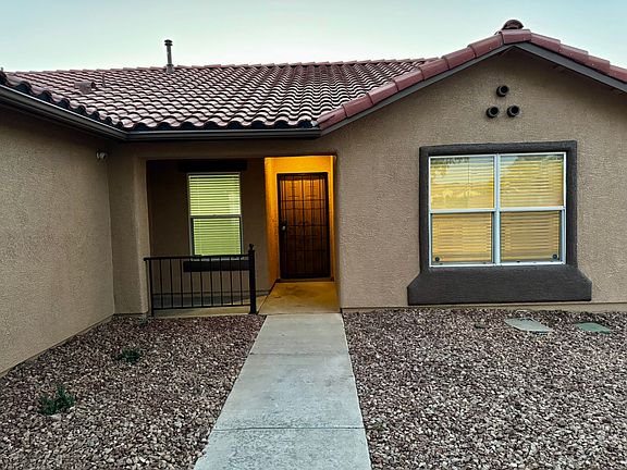 Welcoming entry with warm lighting and low-maintenance desert landscaping.