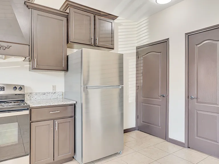 Interior view of a kitchen at Merida Vista Apartments, showcasing stainless steel appliances and a refrigerator