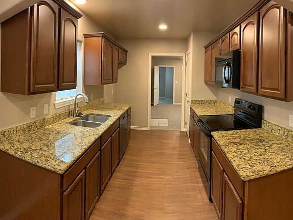 Kitchen with granite countertops and electric stove, oven, and microwave.