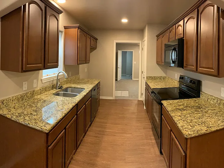 Kitchen with granite countertops and electric stove, oven, and microwave.