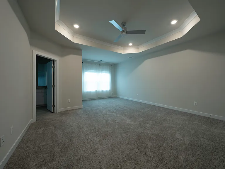 Large Owner's Bedroom features tray ceiling, TWO walk-in closets (one is a huge 12.5' x 6.5'), en suite bathroom, and smart ceiling fan