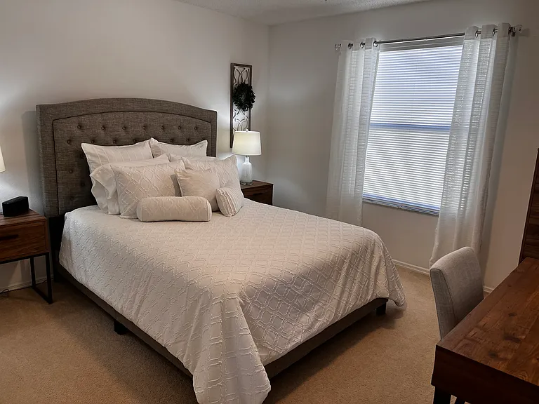 Second bedroom with queen size bed and a desk for a work area.