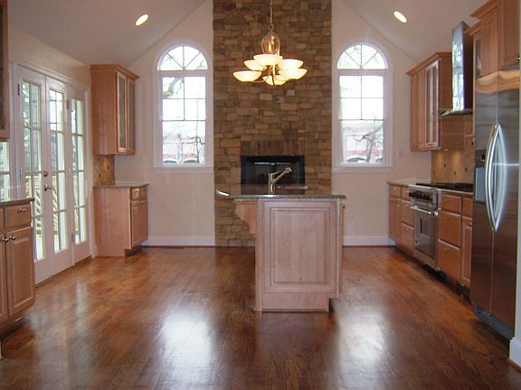Kitchen has a stacked stone fireplace and granite countertops