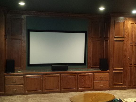 Theater : A theater with a projector, screen, and custom woodwork.