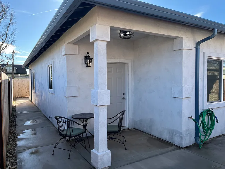 Covered patio with hose spigot.