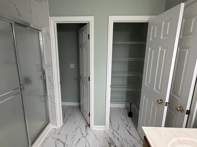 Master bath with linen closet and toilet section.