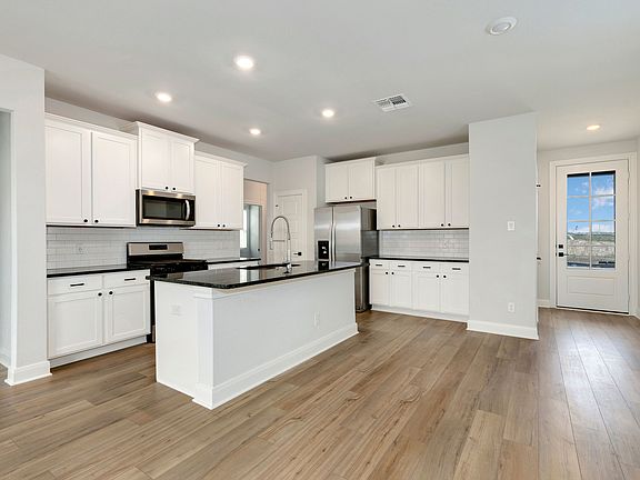Upgraded kitchen with black countertops and white cabinetry.
