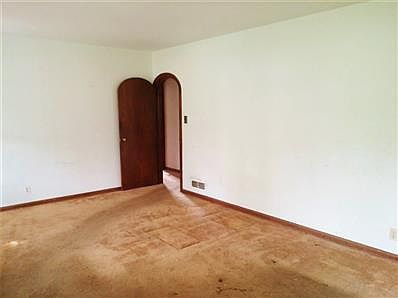 Classic arched doorway connects the living room to the bedrooms and bath.