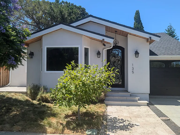 Magnolia tree in front of house, jacaranda tree on the left. Grass is California native (no-mow) and is watered using subterranean irrigation to avoid water waste.