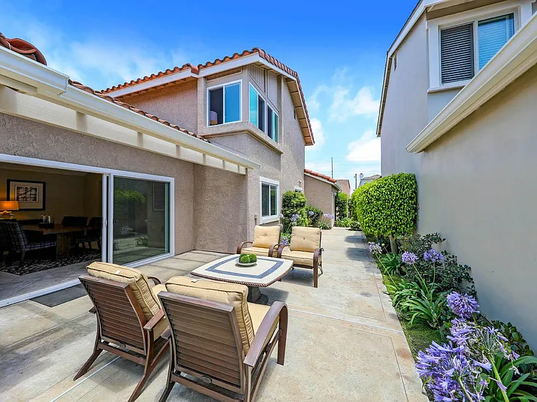 Patio yard with view of upstairs master and 3 car garage in very back.