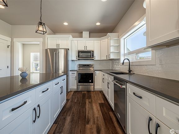 Spacious kitchen with granite counters, soft close cabinetry, and stainless KitchenAid appliances with gas cooktop.