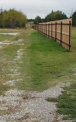 Stay left of this wood fence and follow road north to metal gate entering property