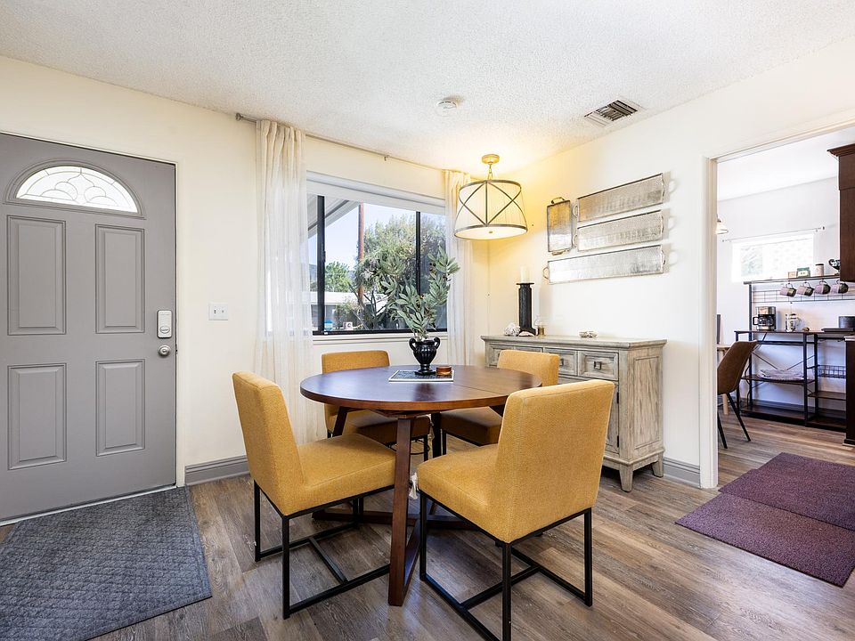 Available extension leaf to dining table to fit six is placed under sofa against the wall.