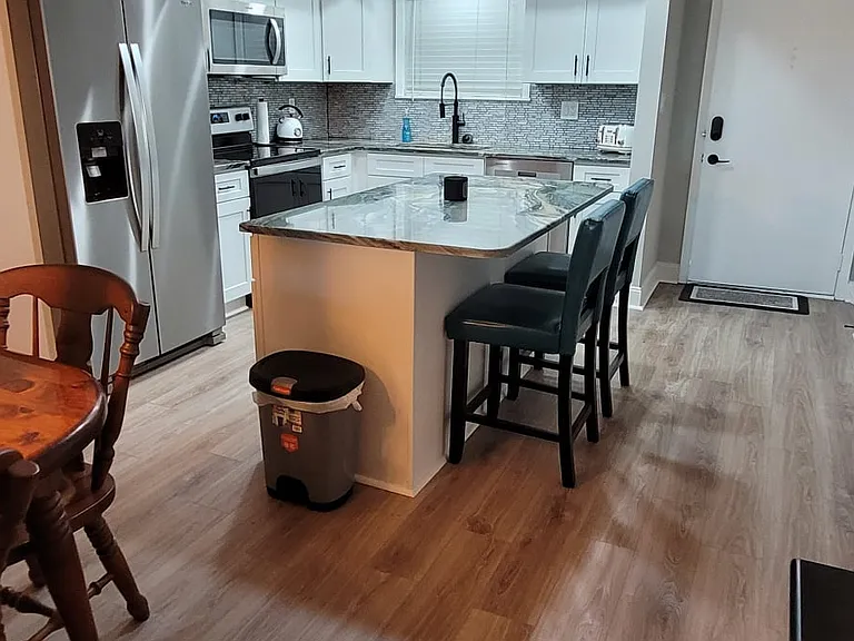Reverse view of the renovated kitchen and front door to the condo.