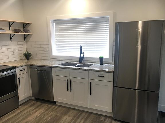 Kitchen with dual sink, D/W, refrigerator/freezer. All appliances are stainless steel.