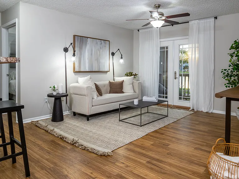 Step into comfort with this beautifully styled living room featuring wood-style flooring, natural light, and modern finishesperfect for relaxing or entertaining.