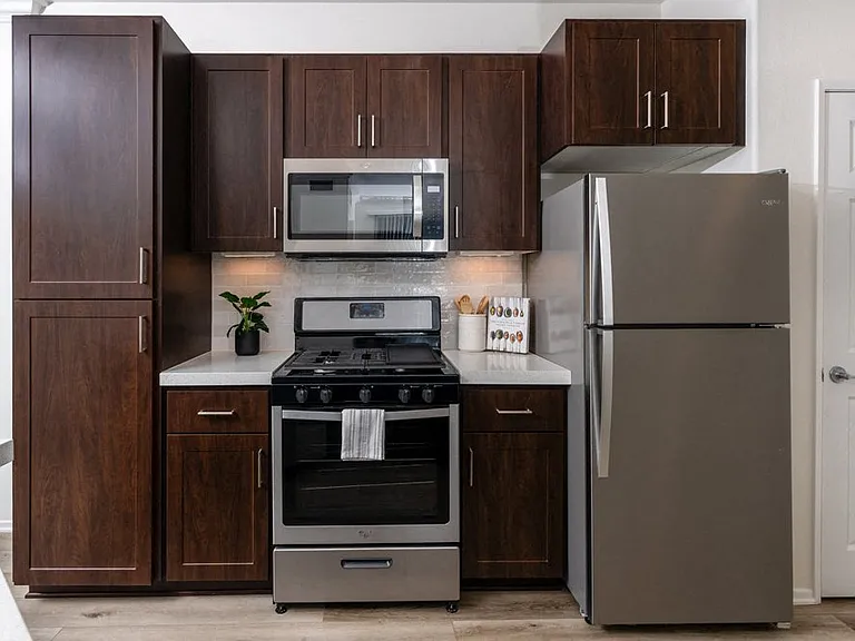 Apartment Kitchen with Dark Cabinetry, Full Appliance Suite, and Subway Tile Backsplash