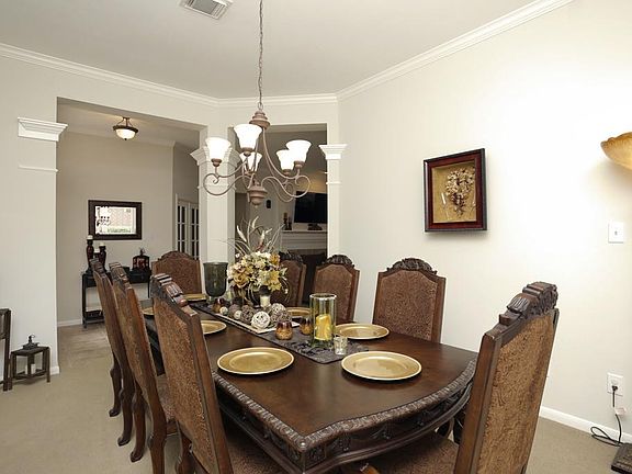 Dining room looking to open tiled foyer. Neutral carpet in dining room.