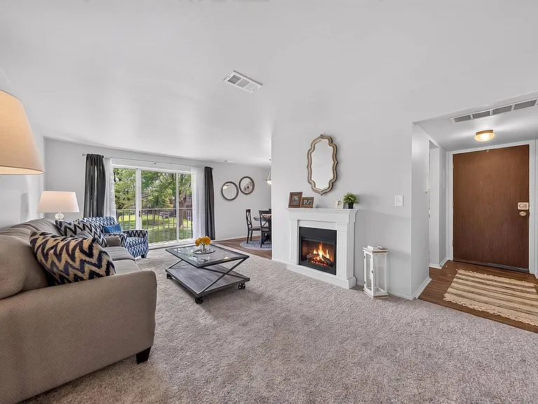 Elevated living room with a private balcony at Drawbridge Apartments in Harrison Township, MI.
